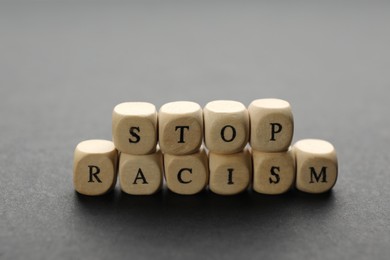 Phrase Stop Racism made of wooden cubes on grey table
