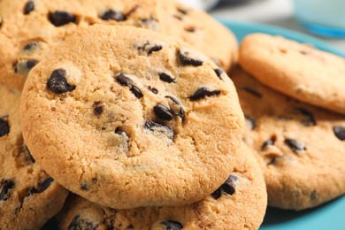 Photo of Many delicious chocolate chip cookies on plate, closeup