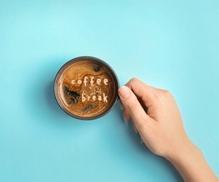 Coffee Break. Woman with cup of americano on turquoise background, top view
