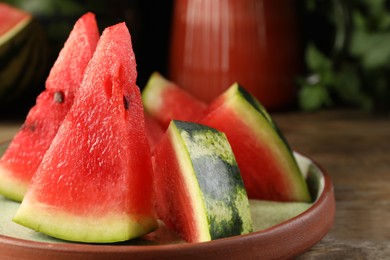 Plate with slices of juicy watermelon on wooden table, closeup. Space for text