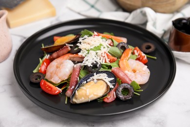 Photo of Plate of delicious salad with seafood on white marble table, closeup