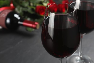 Glasses of red wine on black table, closeup. Space for text
