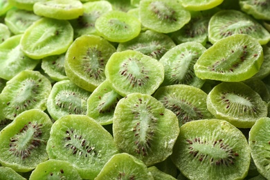 Tasty slices of kiwi as background, closeup. Dried fruit as healthy food
