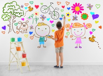 Cute child boy drawing of colorful dye many different picture on white wall