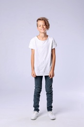 Cute little boy in casual outfit on light background