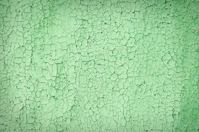 Photo of Texture of cracked light green wall as background, closeup