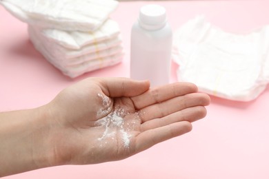 Photo of Woman with dusting powder on pink background, closeup