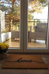 Photo of Doormat with word Home on parquet floor indoors