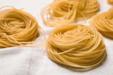 Capellini pasta on white tablecloth, closeup view