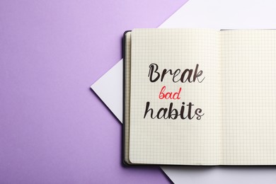 Open notebook with phrase Break bad habits on violet background, top view. Space for text