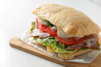 Delicious sandwich with fresh vegetables and mozzarella on white table, closeup