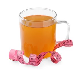 Glass cup of diet herbal tea and measuring tape on white background. Weight loss