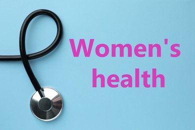 Photo of Words Women's Health and stethoscope on light blue background, top view