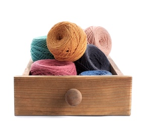 Wooden drawer with clews of colorful knitting threads on white background