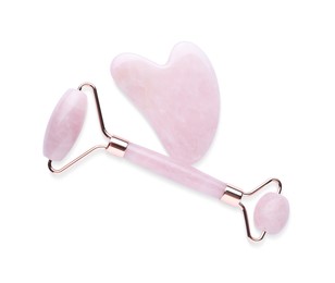 Rose quartz gua sha tool and facial roller isolated on white, top view