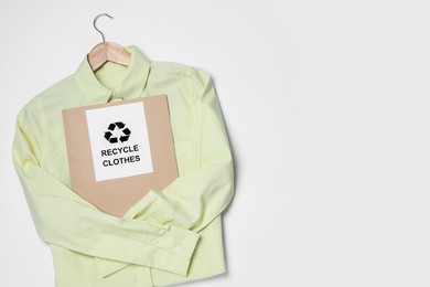 Shirt and card with recycling symbol on white background, top view. Space for text