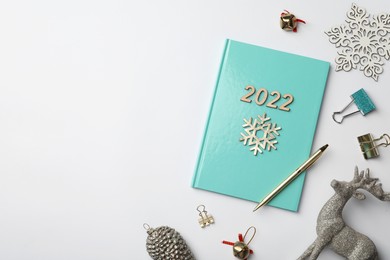 Stylish planner and Christmas decor on white background, flat lay with space for text. 2022 New Year aims