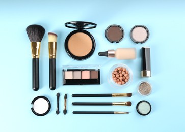Flat lay composition with makeup brushes on light blue background
