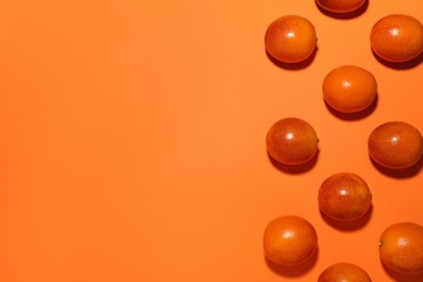 Many ripe sicilian oranges on orange background, flat lay. Space for text