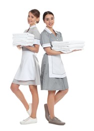 Full length portrait of chambermaids with towels on white background