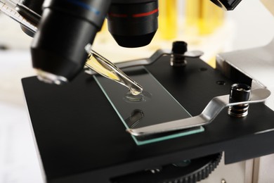 Photo of Microscope with drop of urine on glass slide, closeup