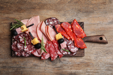 Photo of Tasty ham with other delicacies served on wooden table, top view
