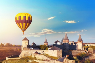KAMIANETS-PODILSKYI, UKRAINE - OCTOBER 06, 2018: Beautiful view of hot air balloon flying near Kamianets-Podilskyi Castle