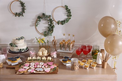 Baby shower party. Different delicious treats and drinks on wooden table indoors