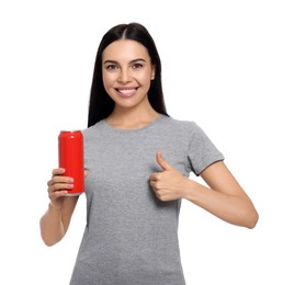 Beautiful happy woman holding red beverage can and showing thumbs up on white background