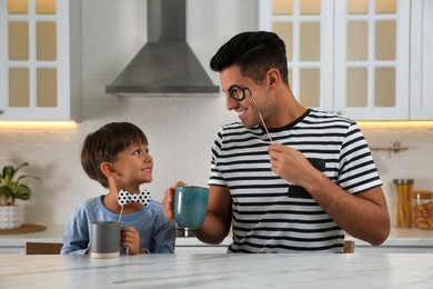 Dad and his son having fun in kitchen. Happy Father's Day