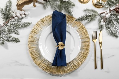 Photo of Stylish table setting with dark blue fabric napkin, beautiful decorative ring and festive decor, flat lay