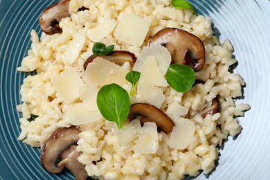 Photo of Delicious risotto with cheese and mushrooms on plate, closeup