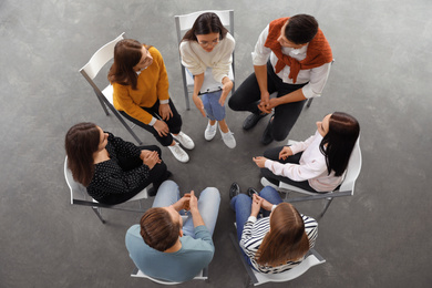 Psychotherapist working with patients in group therapy session, top view