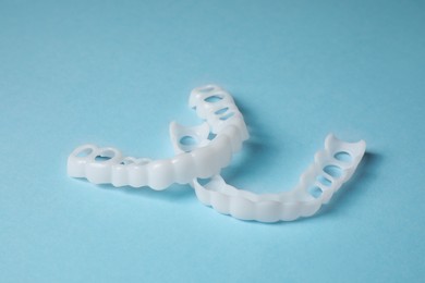 Photo of Dental mouth guards on light blue background. Bite correction
