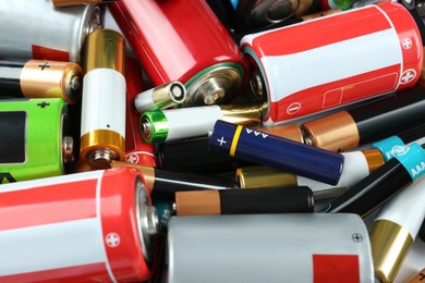 Image of Many batteries of different types as background, closeup view
