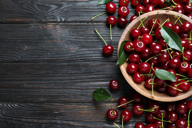 Delicious ripe sweet cherries on dark wooden table, flat lay. Space for text