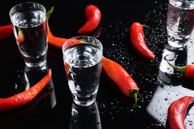 Red hot chili peppers and vodka on black table