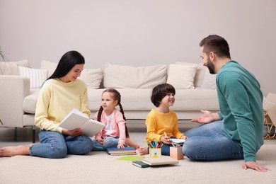 Photo of Happy family spending time together on floor in living room