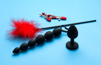 Photo of Sex toys and accessories on light blue background