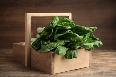 Fresh green pak choy cabbages in crate on wooden table
