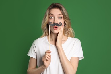 Photo of Emotional woman with fake mustache on green background