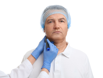 Surgeon with marker preparing man for operation against white background. Double chin removal