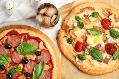 Photo of Delicious pita pizzas and cold drink on white marble table, flat lay