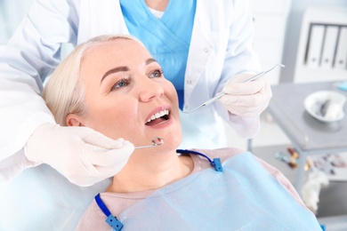 Dentist examining patient's teeth in modern clinic