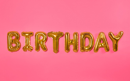 Word BIRTHDAY made of foil balloon letters on pink background