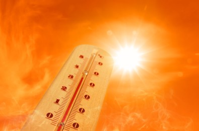 Image of Weather thermometer with high temperature outdoors on hot sunny day. Heat stroke warning
