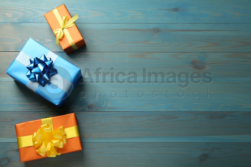Different gift boxes on light blue wooden table, flat lay. Space for text