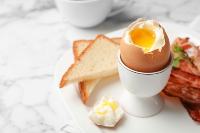 Holder with soft boiled egg, bread and bacon on plate. Space for text