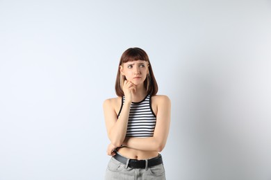 Photo of Portrait of confused young girl on white background