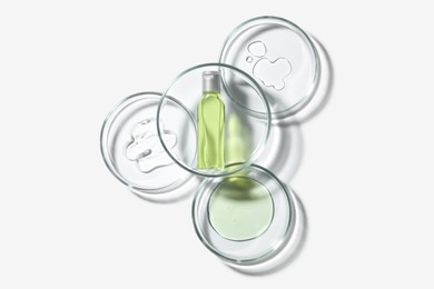 Photo of Petri dishes with samples and bottle on white background, top view